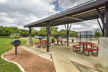 A picnic area with tables and benches under a shelter.